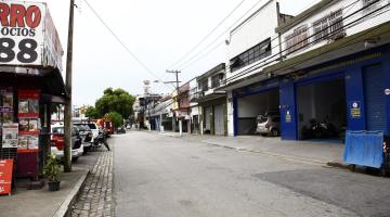 trecho de avenida sem movimento de carros. Ao lado direito há estabelecimentos comerciais; do esquerdo, o canteiro central. #paratodosverem