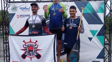 Atletas no pódio com medalha #paratodosverem