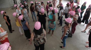 Servidoras com capacetes rosa observam obra em andamento. #pratodosverem