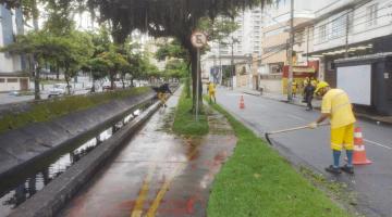 trabalhadores realizam capinação em jardim ao lado de ciclovia e canal #paratodosverem