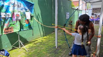 Criança participa de brincadeiras no NAPS. #Paratodosverem.