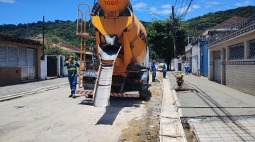 caminhão betoneira está parado em via ao lado de calçada em construção. #paratodosverem 