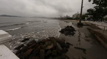 a ponta da praia em tom escuro, prenúncio de chuva. #paratodosverem 