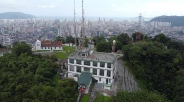 vista aérea geral de morro (o monte serrat), com construção e grande área verde em torno. #paratodosverem