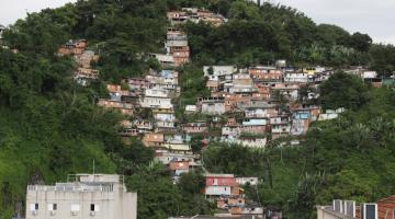 vista geral do monte serrat, com moradias à frent, cercadas por vegetação. #paratodosverem