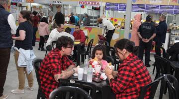 pessoas sentadas comendo na festa #paratodosverem
