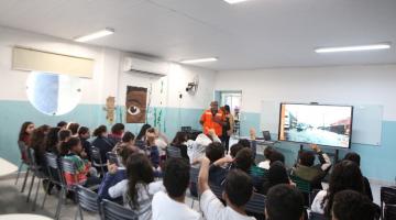 crianças em sala de aula assistem palestra. #paratodosverem 