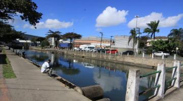 Foto do canal com homem sentado na beirada - #paratodosverem