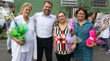 homenageadas posam com flores e secretário #paratodosverem