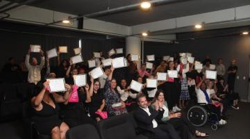 pessoas sentadas levantando diploma #paratodosverem