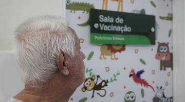 close de idoso diante de sala de vacinação. #paratodosverem