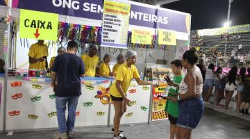 pessoas sendo seevidas por funcionário de barraca #paratodosverem