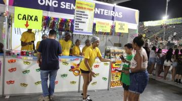 pessoas comprando lanches em barraca de entidade #paratodosverem