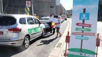 carros estão em fila e são decorados com bexigas coloridas. #paratodosverem