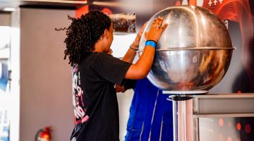 menina encosta em bola prateada #paratodosverem 