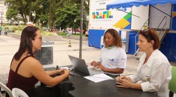 mulher sendo atendida em mesa na frente da carreta #paratodosverem
