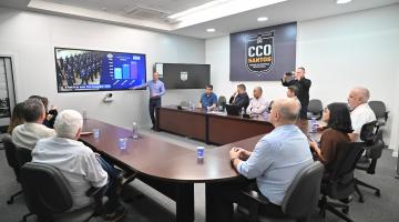 pessoas em mesa vendo apresentação #paratodosverem