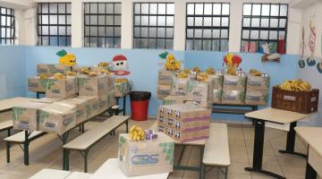 Caixas com alimentos estão sobre mesas escolas. #Paratodosverem