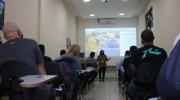 Mulher dá palestra para agentes. #paratodosverem