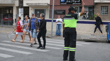 agente auxilia pessoas na travessia #paratodosverem