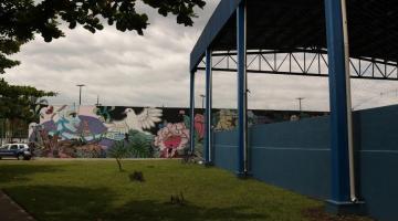 Fachada do CEU das Artes com mural grafitado e parte de cobertura de quadra poliesportiva. #pracegover