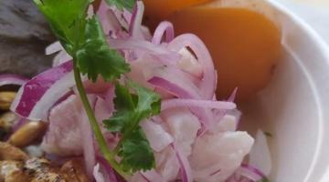 Prato de ceviche, com peixe, cebola, milho peruano e folhas de coentro. #Paratodosverem