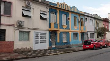 Rua com sobrados de fachadas coloridas. #paratodosverem
