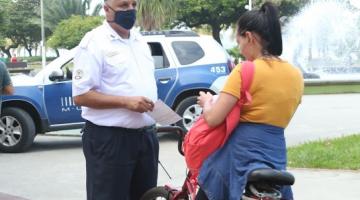 Agente da Guarda Municipal está diante de ciclista sem máscara. #Paratodosverem