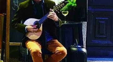 rapaz toca violão em palco #paratodosverem