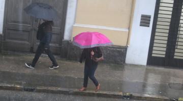 pessoas de guareda chuva na rua #paratodosverem 