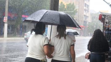 pessoas de guarda chuva na rua #paratodosverem