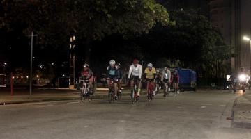 ciclistas pedalam na avenida da orla de madrugada #paratodosverem