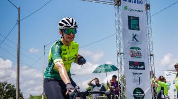 a atleta está cruzando a linha de chegada de bicicleta. #paratodosverem