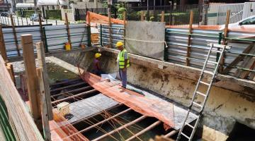 operários no meio de canal durante a obra #paratodosverem