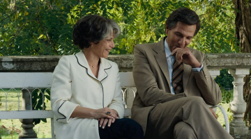 casal sentado lado a lado em área livre. #paratodosverem