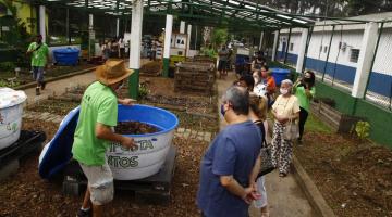 Canteiro de mudas de plantas com pessoas assistindo a orientações sobre sistema de compostagem. #aratodosverem