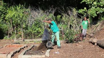 homem despeja compostos orgânicos em canteiro de jardim. #paratodosverem