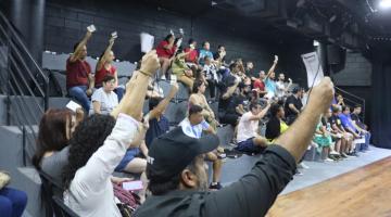 pessoas mostram papel na conferência #paratodosverem 