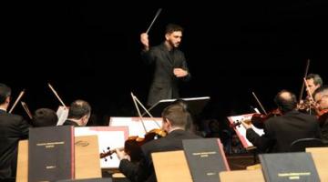 O maestro josé consani diante dos músicos da orquestra. #Paratodosverem