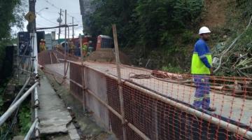 Estrutra de obras armada com funcionários no pé do morro #paratodosverem