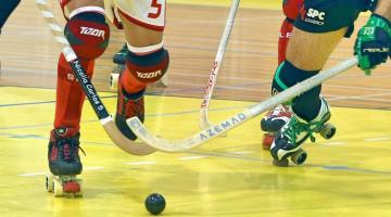 close de disputa de bola entre dois jogados de hóquei sobre patins. Um taco de cada lado é direcionado à bola. #paratodosverem