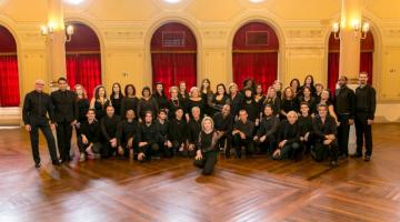 músicos de coral posam para foto em teatro. #paratodosverem 