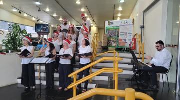 votsl dr sptrdrnyns à frente de uma escadaria em ambiente decorado de natal. #paratodosverem 