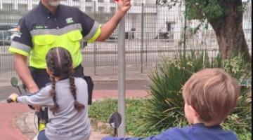 crianças de bicicleta são orientadas por agente #paratodosverem 