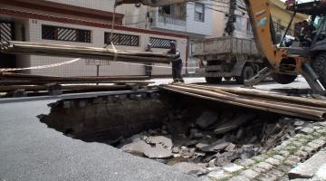 trator carrega placas de madeira para cobrir trecho. #paratodosverem