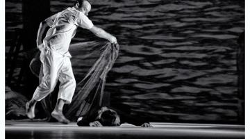 cena de homem cobrindo o corpo de um homem no chão com uma espécie de rede ou véu