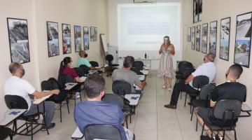 pessoas sentadas em sala observam explicações de palestrante #paratodosverem