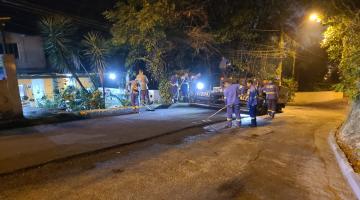 homens estão pavimentando rua à noite. #paratodosverem