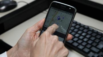 mãos tocam em tela de celular com localização em mapa. #paratodosverem