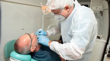 dentista examina boca de paciente. #paratodosverem 